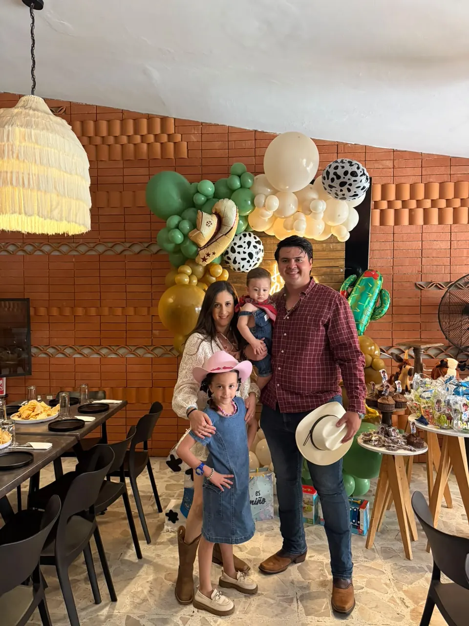 Familia en un primer cumpleaños con decoración vaquera