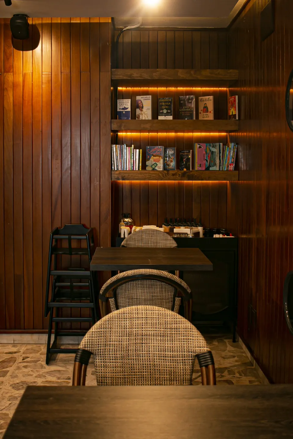 Rincón con libros, mesas y silla para bebé